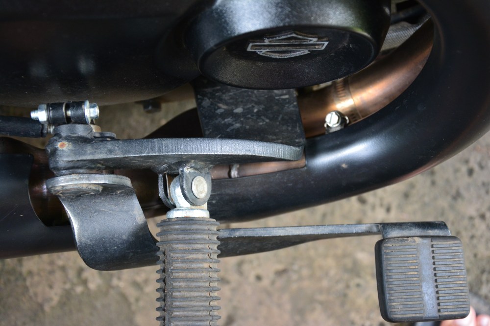 Rear Brake lever. Look here at the quality of the holder. Again here the design team thought "Ohhh!! how do we accommodate the rear brake assembly. okay lets take cheap wrought iron lets not even polish it, then lets bolt it to engine assembly beneath and voila its done "